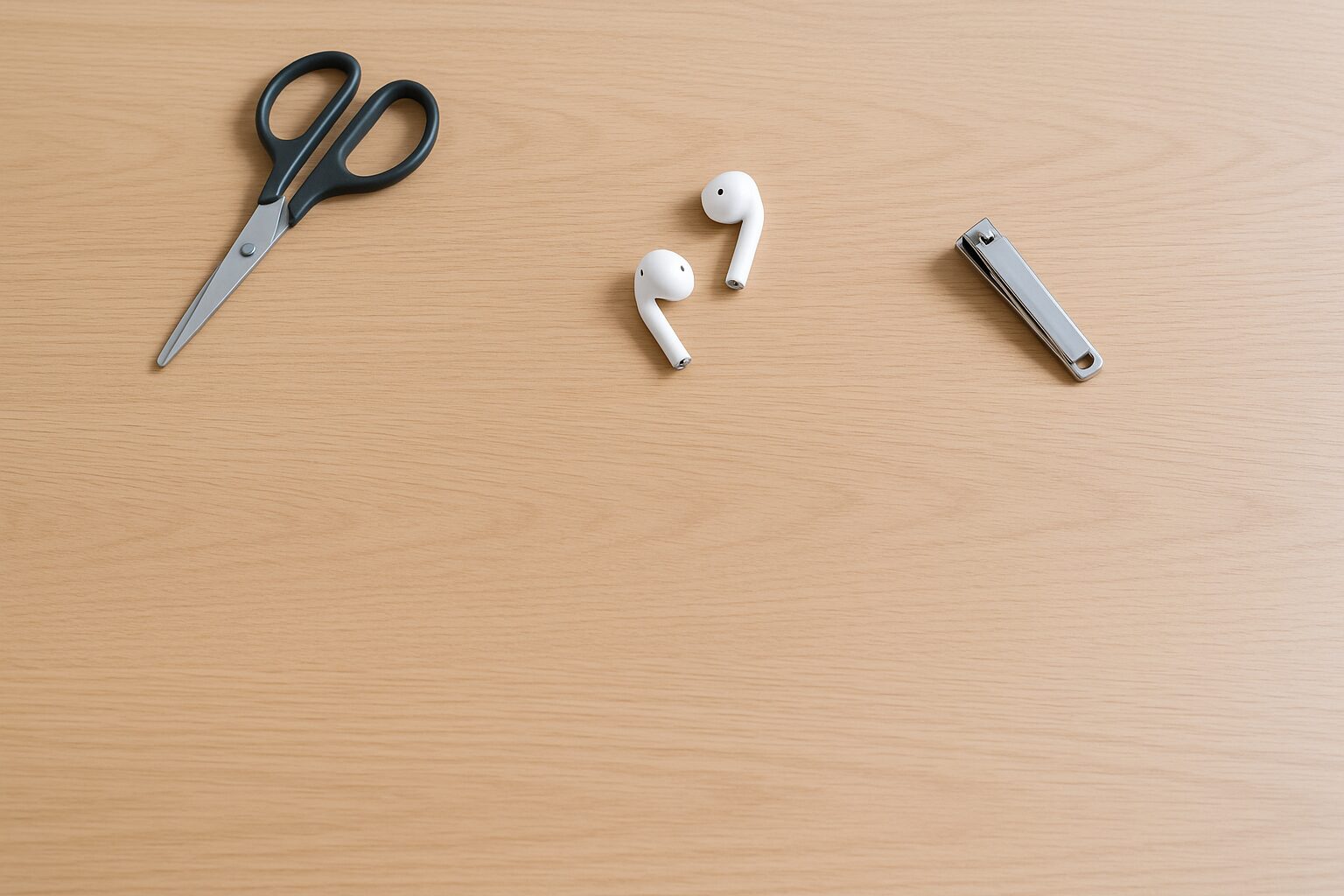 木目デスクの上に白い浅型トレーが置かれ、ハサミ・ワイヤレスイヤホン・爪切りが静かに並んでいる俯瞰シーン。自然光で落ち着いた作業空間。